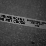 Black and white close-up of crime scene tape with Nashville text.
